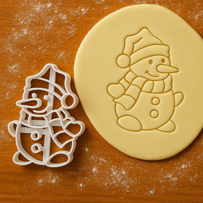 Emporte pièce bonhomme de neige de Noël découpant un biscuit maison en pâte sablée