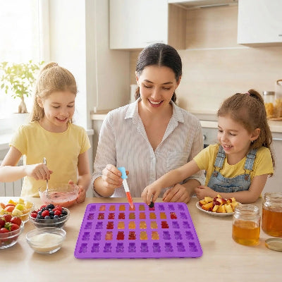 Femme avec deux filles preparant bonbons forme ourses dans moules en silicone