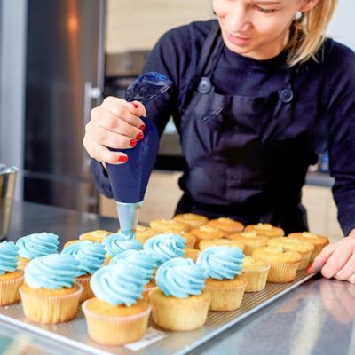 Femme décore gâteau poche à douille professionnelle