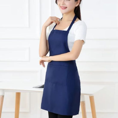 Femme portant un tablier de cuisine bleu marine avec grande poche dans un intérieur moderne