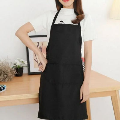 Femme portant un tablier de cuisine noir avec grande poche dans un intérieur moderne