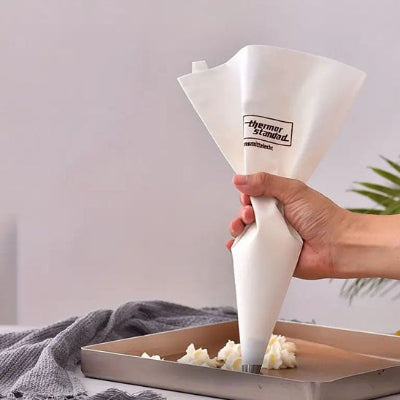 Main tenant une poche à douille lavable grande taille utilisée pour appliquer proprement crème et glaçage sur pâtisserie