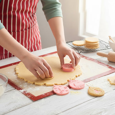 Personne utilisant des emporte pièces de Noël 3D pour découper et imprimer des motifs festifs