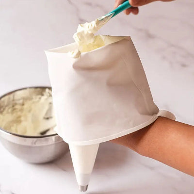 Remplissage d une poche à douille lavable en coton avec de la crème pâtissière avant décoration de dessert maison