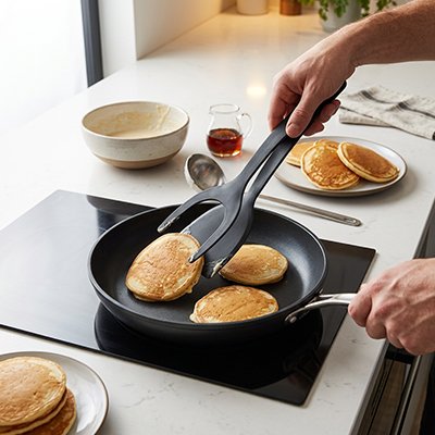 Spatule Cuisine ergonomique utilisée pour retourner des pancakes dans une poêle antiadhésive pendant la cuisson