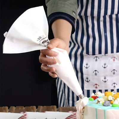 Utilisation d une poche à douille lavable en coton pour appliquer de la crème et réaliser une décoration nette sur un gâteau maison