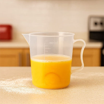 Verre doseur gradué transparent de 1000 ml avec poignée ergonomique et bec verseur contenant liquide jaune