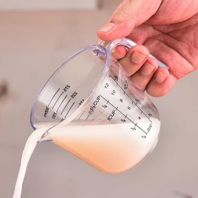 Verre doseur gradué transparent versant lait avec précision grâce à son bec verseur anti goutte