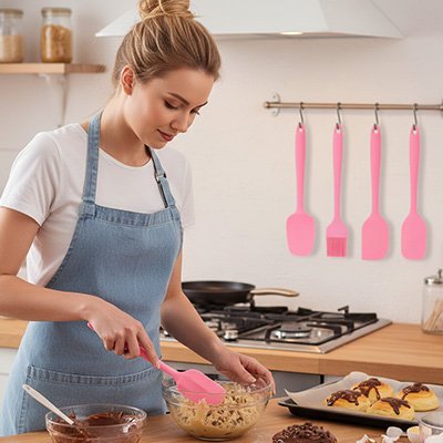 Femme utilisant spatule cuisine en silicone rose pour mélanger préparation pâtissière