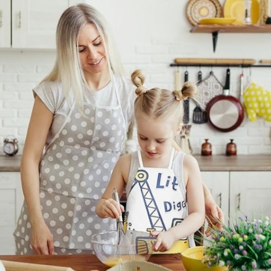 mère et enfant préparant une pâte avec tablier de cuisine enfant motif pelleteuse