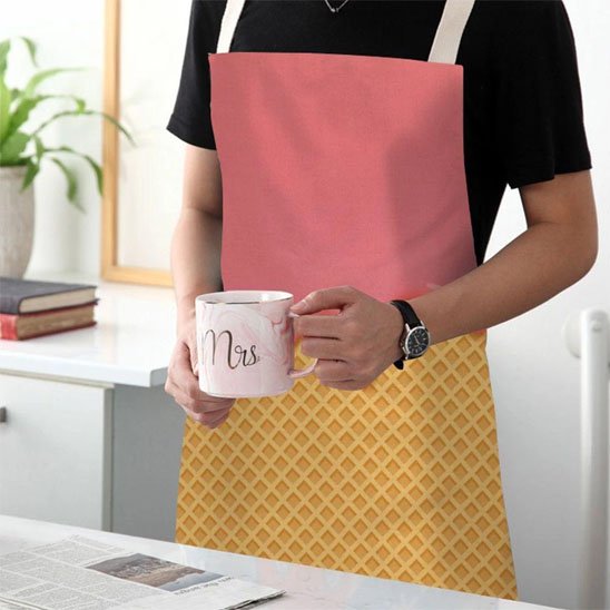 Personne portant tablier de cuisine rose et jaune dans cuisine