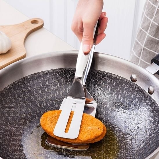 Spatule en acier inoxydable retournant galette dans poêle