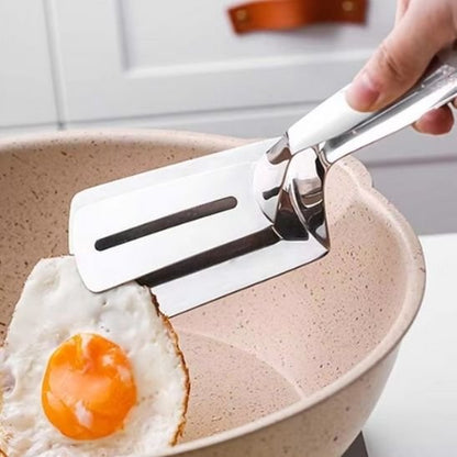 Spatule en acier inoxydable soulevant œuf plat dans poêle