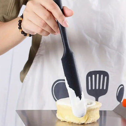Spatule noire utilisée pour étaler la crème sur une pâtisserie