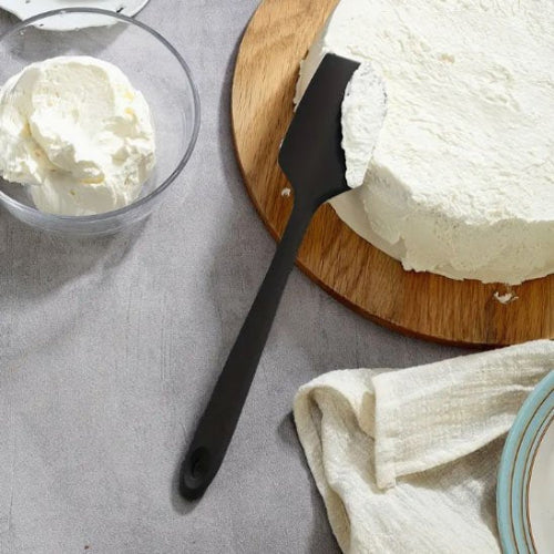 Spatule noire utilisée pour servir une part de gâteau à la crème